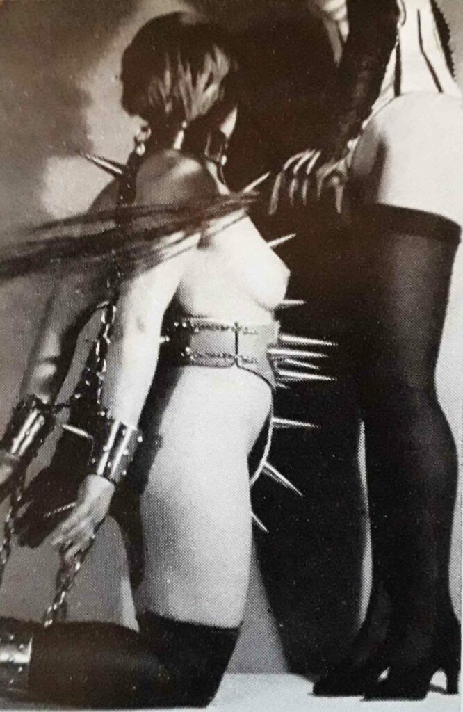 Femme à genoux avec accessoires BDSM vintage