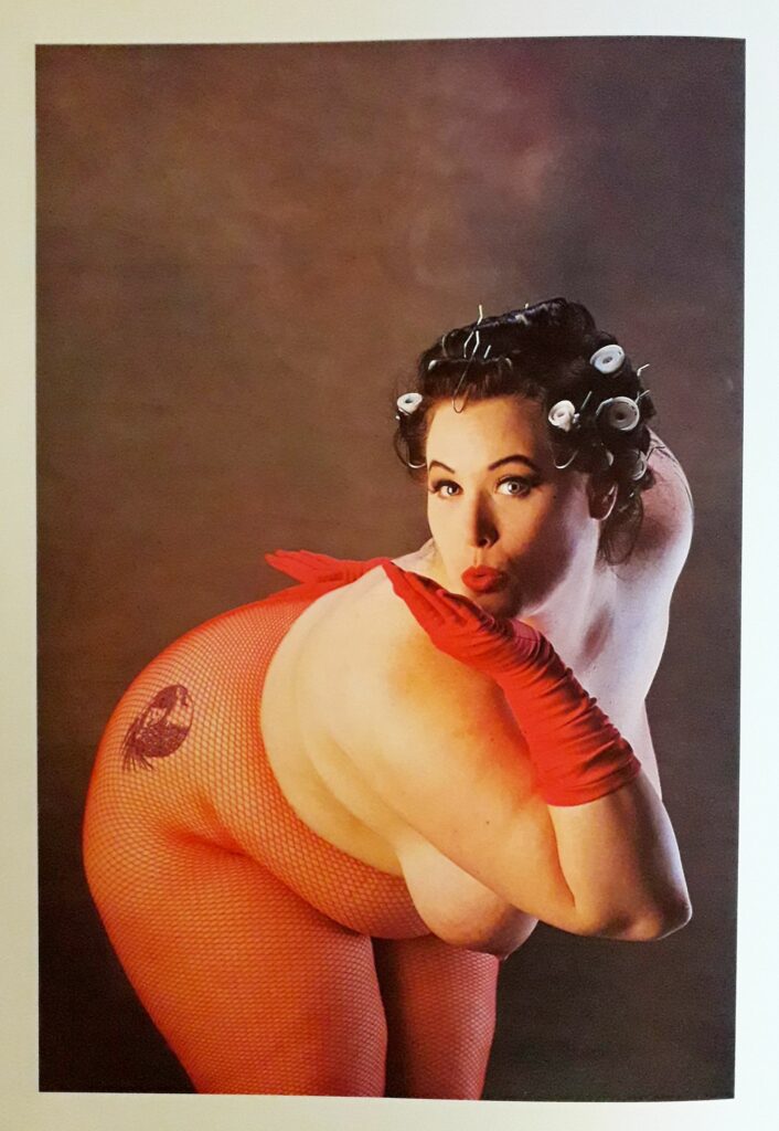 Photo d'Eric Kroll dans Beauty Parade : femme aux gros seins en collants résille rouge.