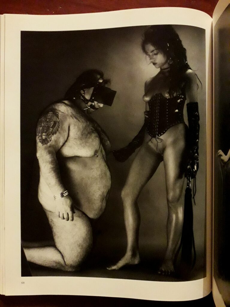 Femme dominante devant un gros homme nu : photo BDSM d'Eric Kroll dans Fetish Girls